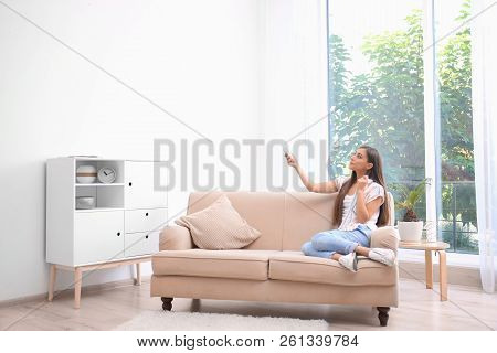 Young Woman Suffering From Heat At Home. Air Conditioner Malfunction