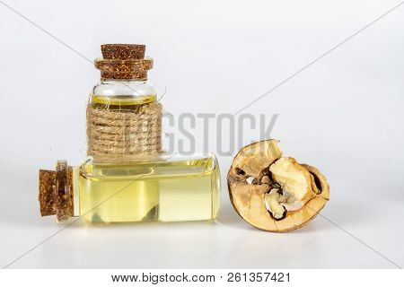 Oil In A Bottle And Walnuts On A White Kitchen Table. Spices And Ingredients Useful In Kuchi.
