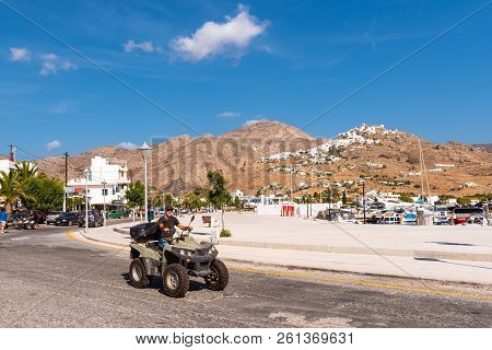 Serifos, Greece - September 8, 2018: Man Driving A Quad On Street Along Sea Bay In Livadi. Cyclades,