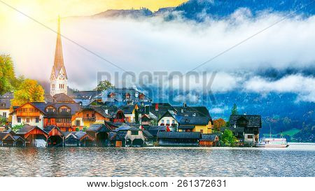 Scenic View Of Famous Hallstatt Mountain Village With Hallstatter Lake. Foggy Autumn Sunrise On Hall