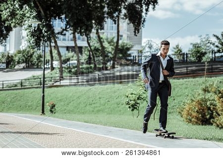 Young Male Student Practicing Riding On Skateboard