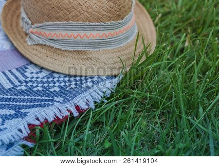 Vintage Summer Wicker Straw Hat With Colorful Ribbon On A Blue Veil On The Lawn In The Park