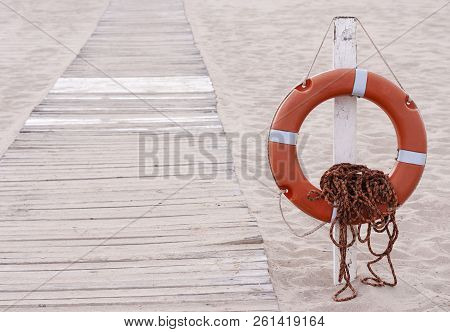 Lifebuoy Next To Boardwalk On The Summer Beach