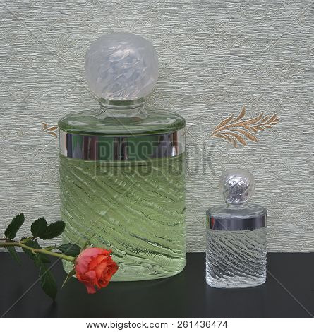 Fragrance For Ladies, Large Perfume Bottle Next To A Commercial Perfume Bottle In Front Of The Satin
