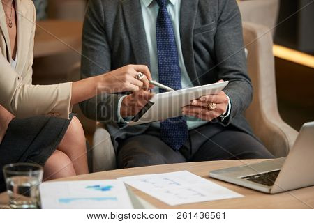 Cropped Image Of Bsuiness Executives Reading Data On Tablet Screen
