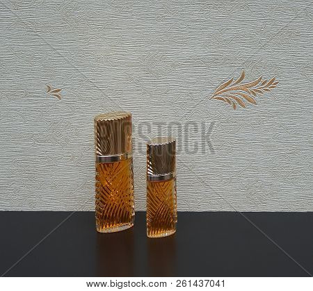Fragrance For Ladies, Large Perfume Bottle Next To A Commercial Perfume Bottle In Front Of The Satin