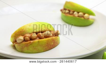 Apple Peanut Butter Monster Mouths On A White Plate. Healthy Halloween Snack