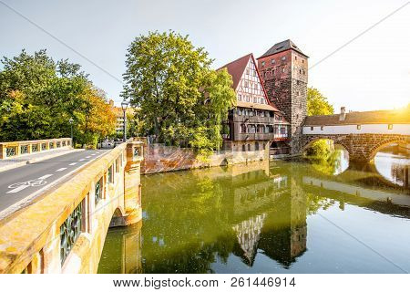 Beautiful Landscape View On The Riverside With Old Tower, House In Nurnberg During The Sunrise, Germ