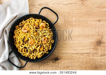 Traditional Spanish Fideua. Noodle Paella On Wooden Table. Top View. Copyspace