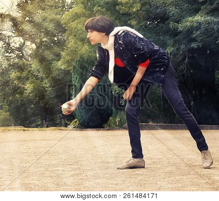 Woman Throwing A Petanque Ball Outdoor In Th Park On Holidays