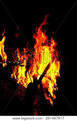 Hot Flames In The Dark. Photo Of Fire Burning At Night, Surrounded By Darkness.
