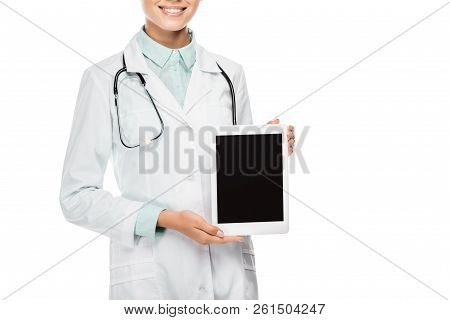 Partial View Of Happy Female Doctor In Medical Coat Showing Digital Tablet With Blank Screen Isolate