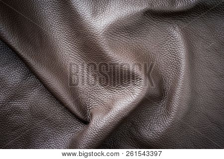 Brown genuine vintage wavy leather as background wallpaper with copy space