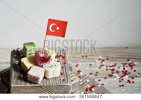 Various National Oriental Sweets, With Paper Flags Of Turkey, Turkish Delight On A Wooden White Brus