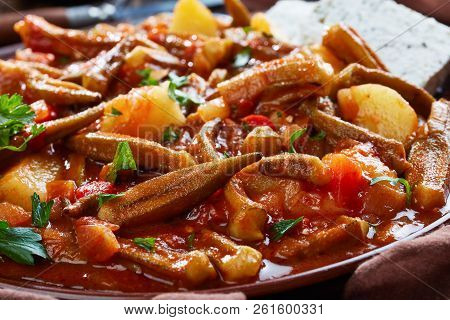 Stewed Okra With Tomato And Potato, Served With Feta Cheese Slices On A Earthenware Plate On A Rusti