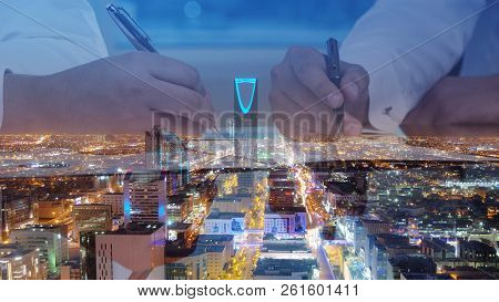 Businessmen Hands Signing Documents On Riyadh Skyline City Scape Background Multi Exposure