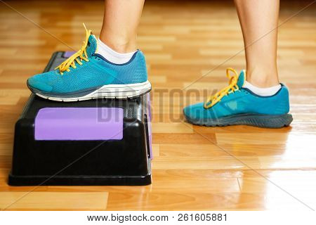 The Girl In Sneakers Is Engaged On The Step-platform For Fitness. Feet On The Step For Sports. Close