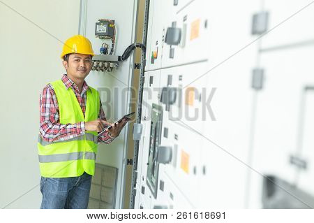 Asian Maintenance Engineers Inspect Relay Protection System With Laptop Computer. Bay Control Unit. 