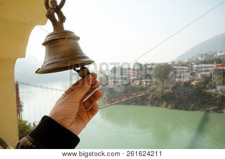 Bell In Tera Manzil Temple. Rishikesh. India. Ringing Of The Bell In The Temple. The Hand Holds The 