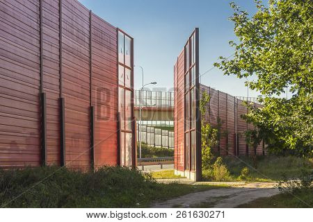 Sound Absorbing Screens Along The Highway. Metal  Frames Filled With Glass And Red Sound-absorbing P