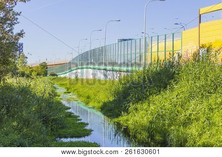 Sound-absorbing Screens Along The Highway And The Creek.metal Frames Filled With Glass And Yellow So