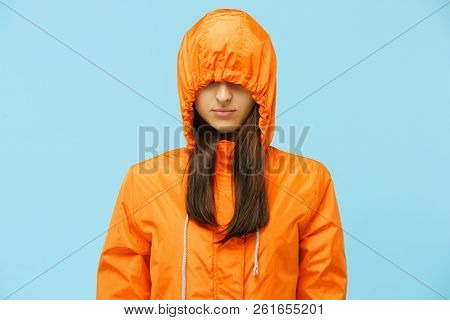 The Young Girl Posing At Studio In Autumn Jacket Isolated On Blue. Human Negative Emotions. Concept 