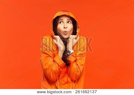 The Young Girl Posing At Studio In Autumn Jacket Isolated On Red. Human Negative Emotions. Concept O
