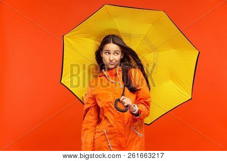 The Young Girl Posing At Studio In Autumn Jacket Isolated On Red. Human Negative Emotions. Concept O