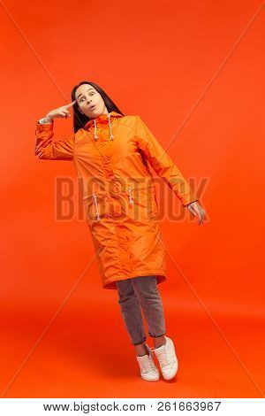 The Young Girl Posing At Studio In Autumn Jacket Isolated On Red. Human Negative Emotions. Concept O