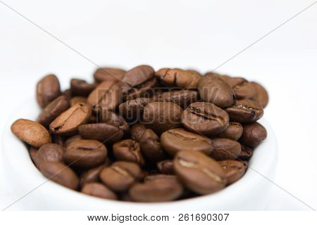 Closeup Coffee Cup With Brown Coffee Beans And Seeds
