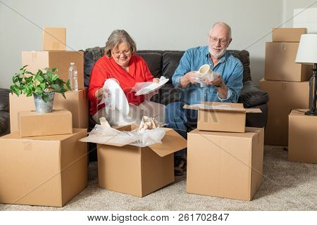 Senior Adult Couple Packing or Unpacking Moving Boxes.