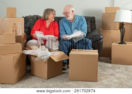 Senior Adult Couple Packing or Unpacking Moving Boxes.