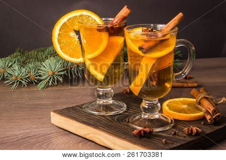 Two Glasses With Delicious Fragrant Tea Of Mulled Wine With Orange And Spices On A Wooden Board With