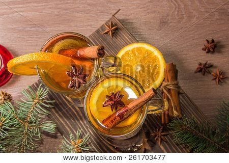 Two Glasses With Delicious Fragrant Tea Of Mulled Wine With Orange And Spices On A Wooden Board With