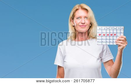 Middle age blonde woman holding menstruation calendar ver isolated background with a confident expression on smart face thinking serious