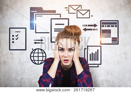 Stressed Young Woman In Checkered Shirt Sitting Near Concrete Wall With Electronic Documents And Int