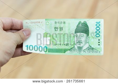Business Man Hold South Korea Banknote 10000 Korean Won On Wood Background