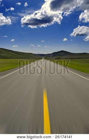 Road med blå himmel og skyer sløret bevægelse at angive hastighed