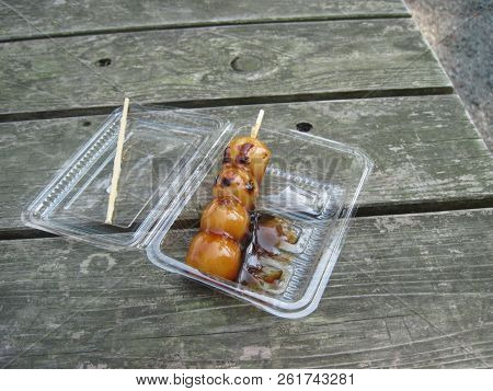 Japanese Mochiko Dumplings On A Stick Siting On Picnic Table