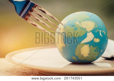 Fork Slammed On Globe Model Placed On Plate  For Serve Menu In Famous Hotel. International Cuisine I