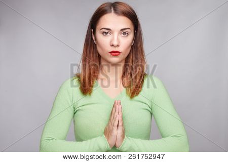 Self Assured Confident Young Female Keeps Hands In Praying Gesture, Wears Green Cashmere Sweater And