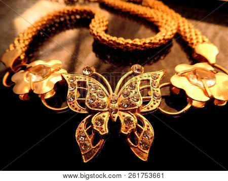 Warm Close Up Image Of Glittering Gold Jewelry Of Diamonds Studded Butterfly With Gold Flowers On Ei