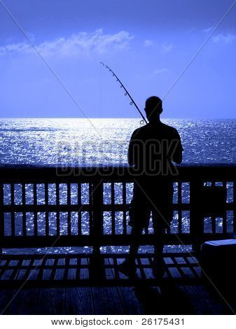 Man ffishing i havet från en träbrygga