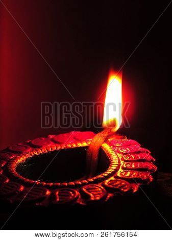 Close Up Isolated Low Key Diwali Oil Clay Lamp,chirag Or Panti On A Dark Orange Black Background Wit