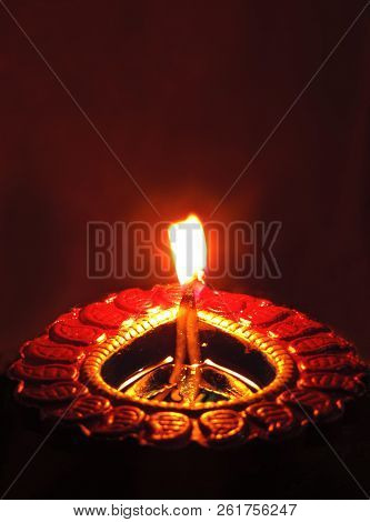 Central Symmetrical Close Up Isolated Low Key Diwali Oil Clay Lamp Or Chirag On Dark Orange Black Ba