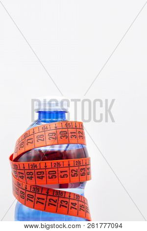 Bottle Of Water And Red Measure Tape