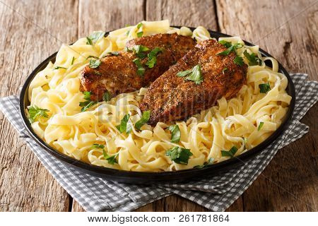 Fried Spicy Chicken Breast Served With Fettuccine Pasta And Cream Sauce Close-up On A Plate On The T