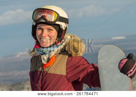 Portrait Of A Snowboarder Woman Freerider In Helmet In Snowy Mountains