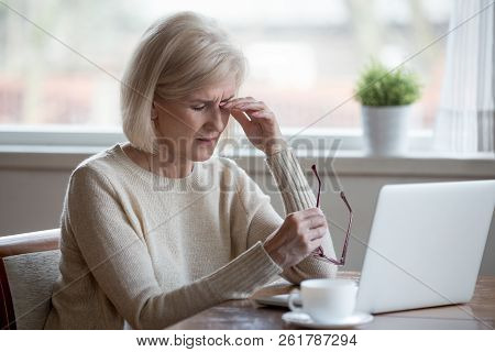 Fatigued Mature Woman Taking Off Glasses Suffering From Eye Stra