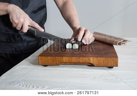 Process Of Making Maki Sushi. Cook Chef Hands Preparing Rolls With Cheese, Avocado And Sesame Seeds 